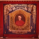 A traditional painted trade union banner depicting a portrait of Cardinal Manning.