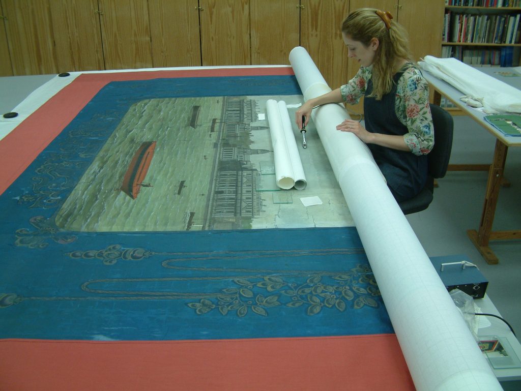 Jenny van Enckevort, PHM Conservator applying conservation support to the Amalgamated Society of Watermen & Lightermen Greenwich Branch No13 Cardinal Manning Lodge banner © People's History