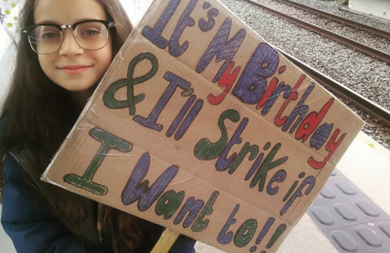 Image of A child holding a placard. The text reads, It's My Birthday & I'll Strike if I Want to!!