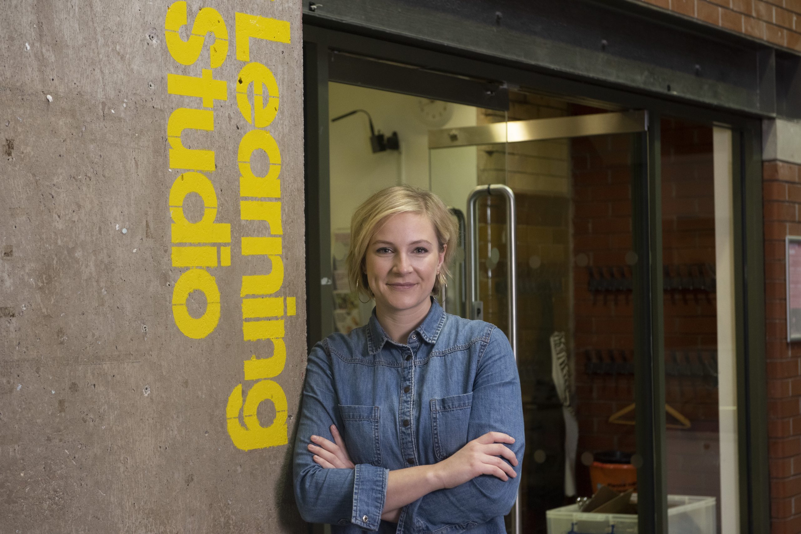 Image of A person standing next to a doorway. The text reads Learning Studio