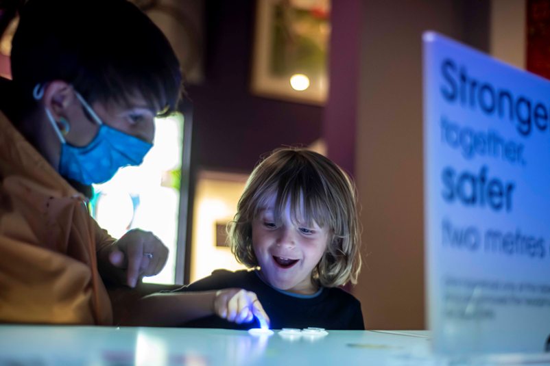 Image of Visitors playing match factory arcade style game in Main Gallery One at People’s History Museum, Manchester