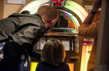 Image of visitors enjoying the juke box in the Time Off? section in Gallery Two at People's History Museum.