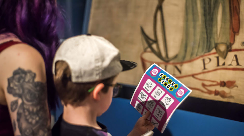 This photo shows a boy looking at the Banner Bingo activity at People's History Museum.
