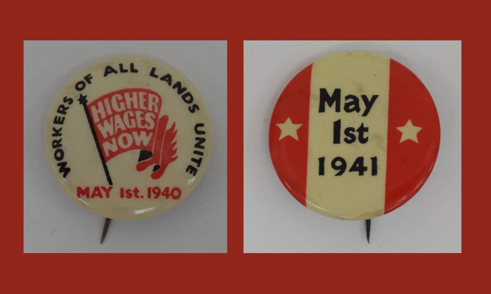 Two red and white May Day badges