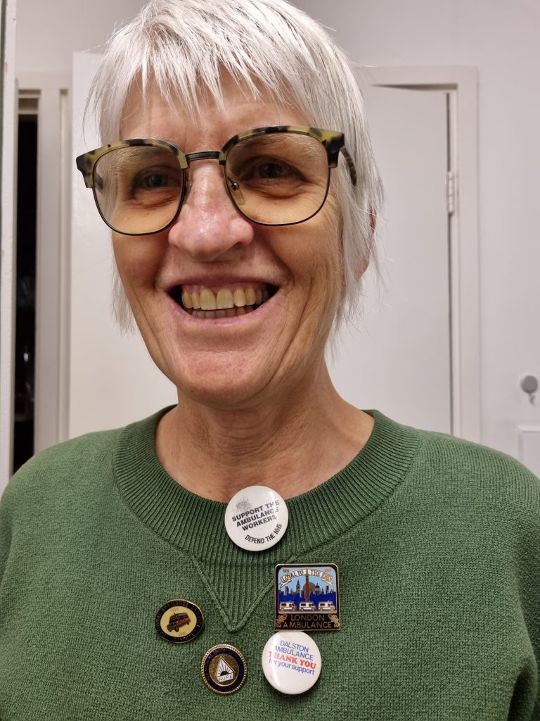 Image of Photograph of Clare Winter wearing her ambulance worker badges. Copyright Clare Winter