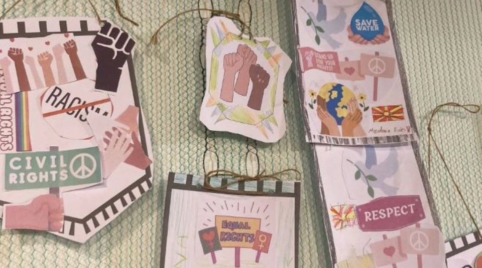 Image of Handmade mini paper banners with symbols including raised fists and peace signs, and text including 'Civil Rights', 'Save Water', and 'Respect'.