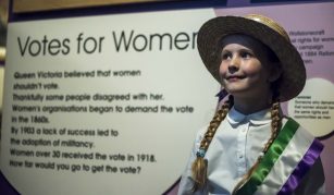 Image of young child in suffragette dress up at People's History Museum.