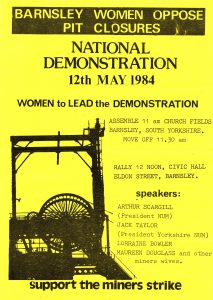 Black text on yellow background, with silhouette image of a pit wheel, text includes ‘WOMEN to LEAD the DEMONSTRATION’.
