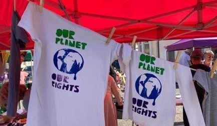 Image of t-shirts pegged on a line with printed text 'OUR PLANET OUR RIGHTS' and an image of earth.