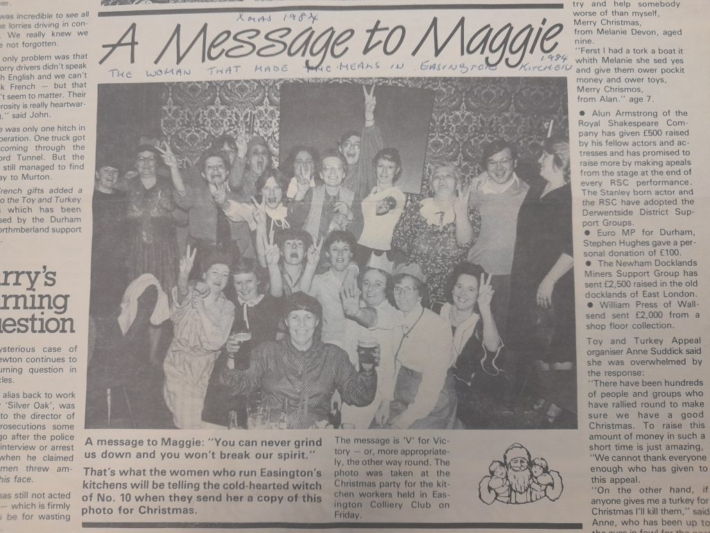 a photograph of a group of women, some wearing paper Christmas hats and using the V hand sign for victory. The text reads: A Message To Maggie.