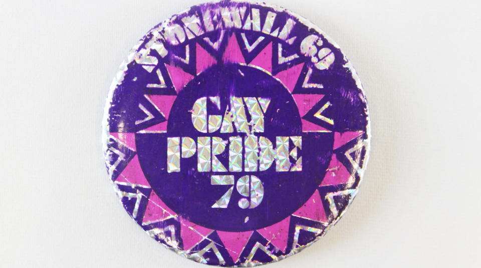 Image of purple, pink, and silver badge with text 'Stonewall 69, Gay Pride 79'.
