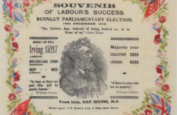 Image of Napkin bordered with red roses and flags, with a central illustration of Dan Irving MP, and black text including: 'Souvenir of Labour's Success, Burnley Parliamentary Election, 14th December 1918.'