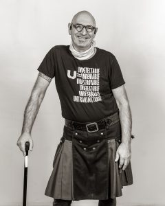 Black and white photograph of a white man (Jonathan Blake) smiling.
