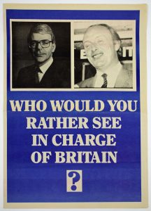 Blue poster with black and white photographs of Conservative Party Prime Minister John Major and Labour Party Leader Neil Kinnock, with white text: 'Who Would You Rather See In Charge Of Britain?'