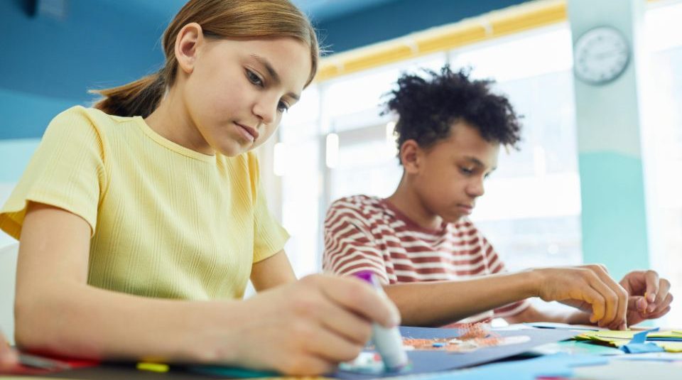 Image of Two children sat at a craft table