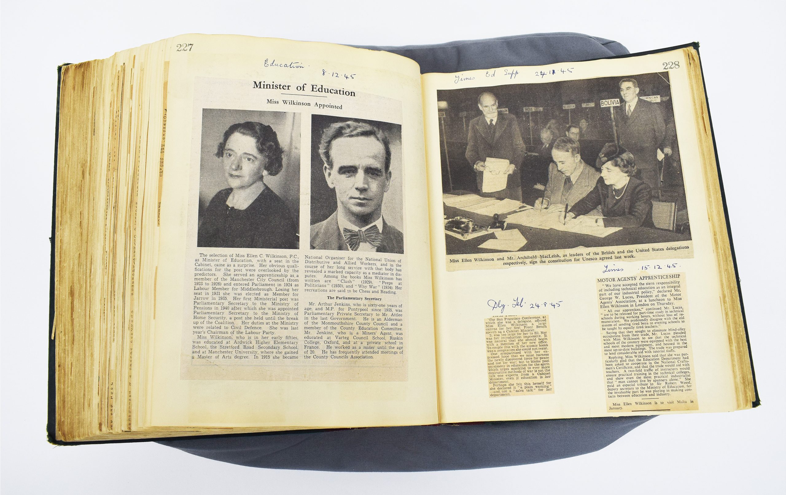 An open scrapbook including black and white newspaper cuttings and photographs.