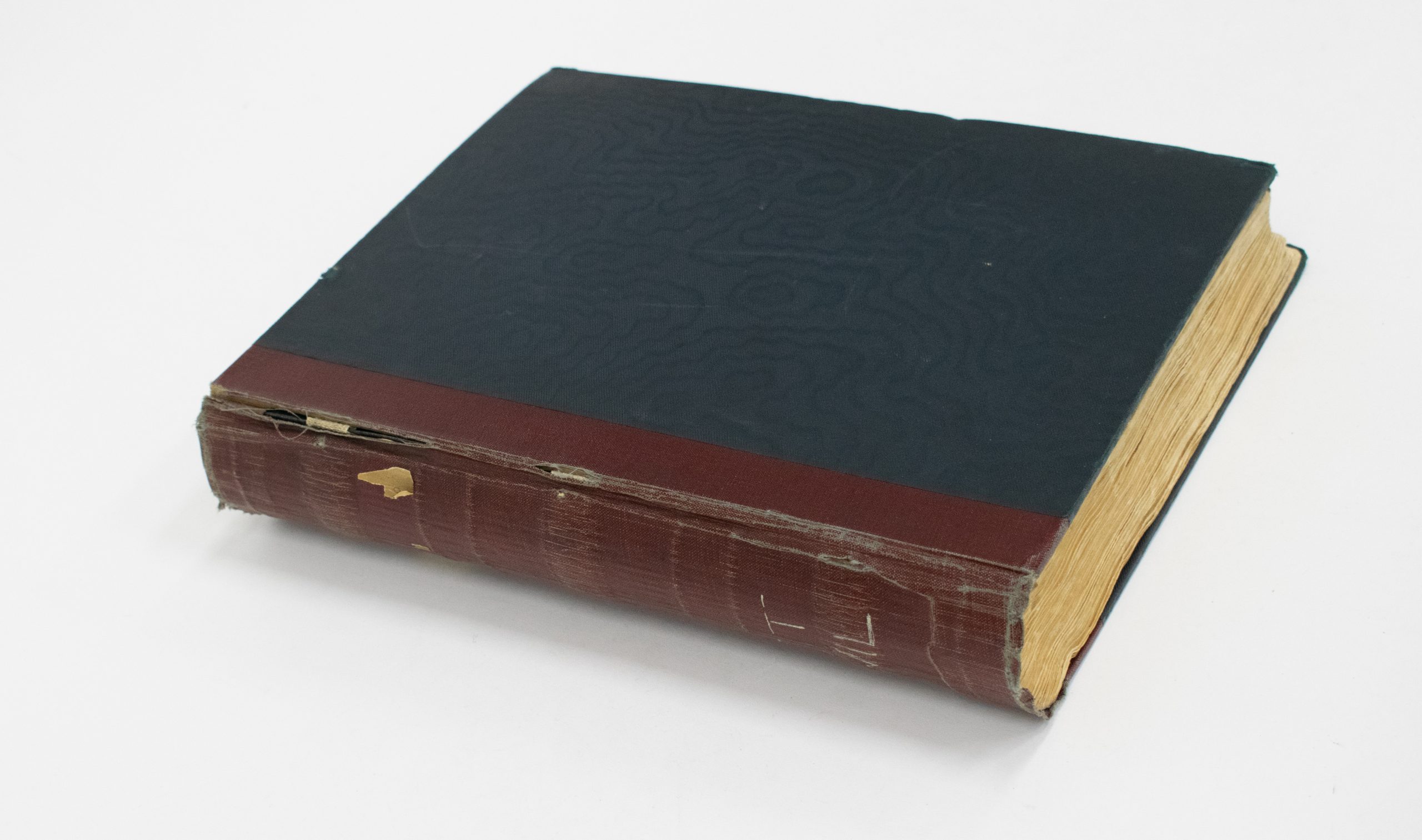 A closed leather bound black scrapbook.