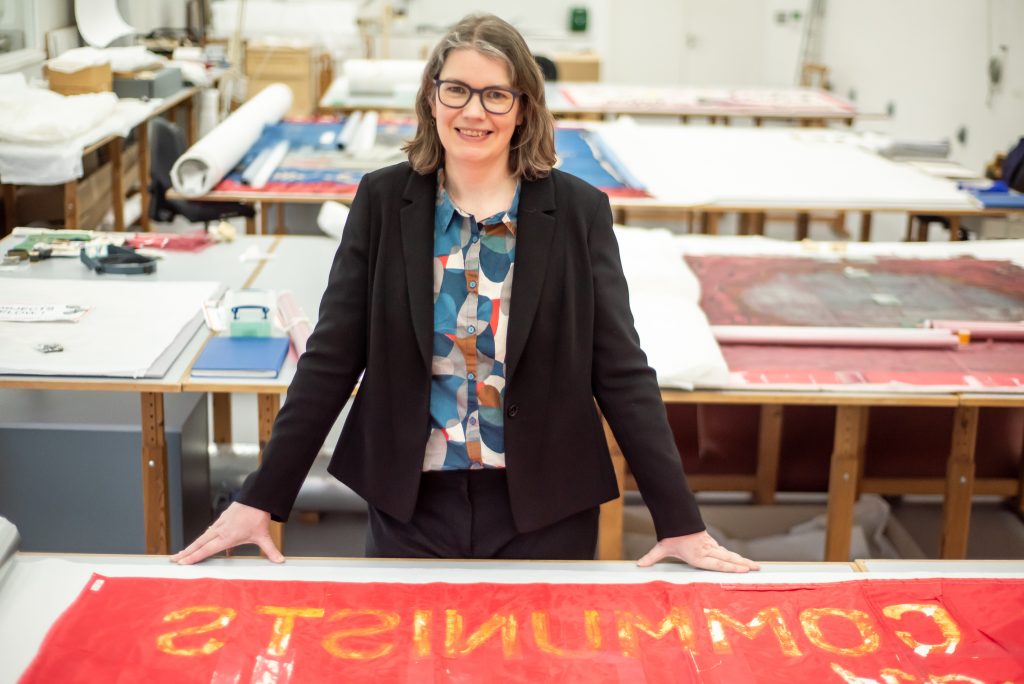 A person standing behind a red banner on a table.