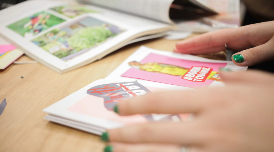 Image of A photograph showing a close up of someone's hands holding open a small zine.