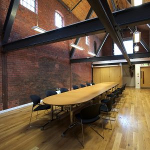 A room with a long table surrounded by chairs