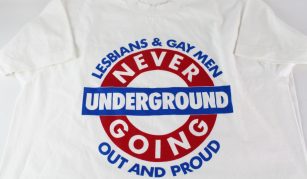 Image of white t-shirt with blue and red London Underground style logo with text: 'Lesbians & Gay Men, Never Going Underground, Out And Proud'.