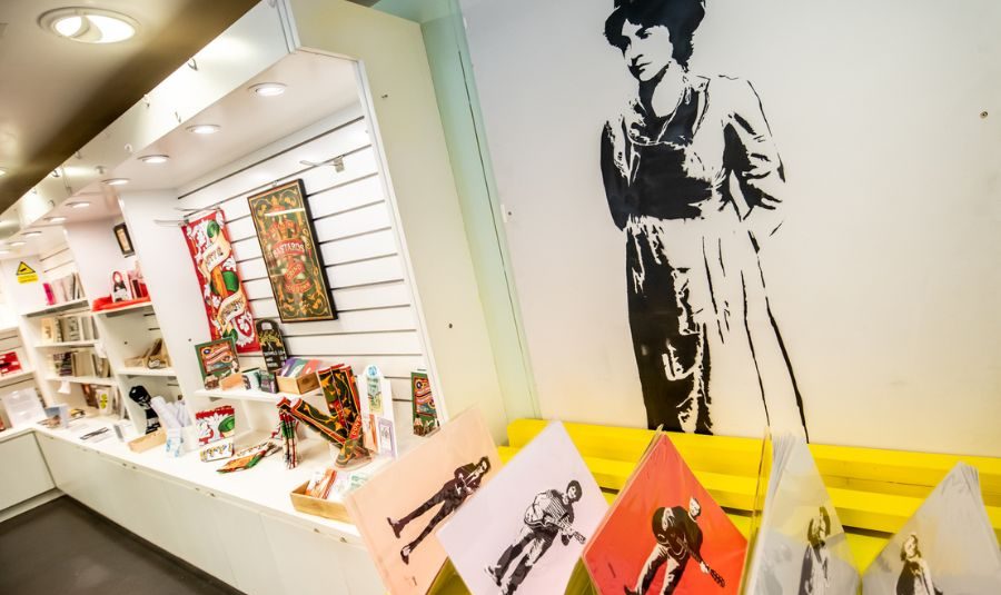 Image of Shop displays including wall mounted artwork and tea towels.