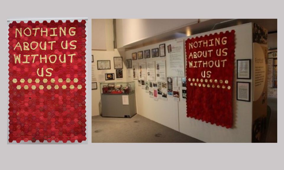 Left to right - A red banner with the words ‘Nothing About Us Without Us’ in gold. Exhibition space featuring red and gold Nothing About Us Without Us banner.