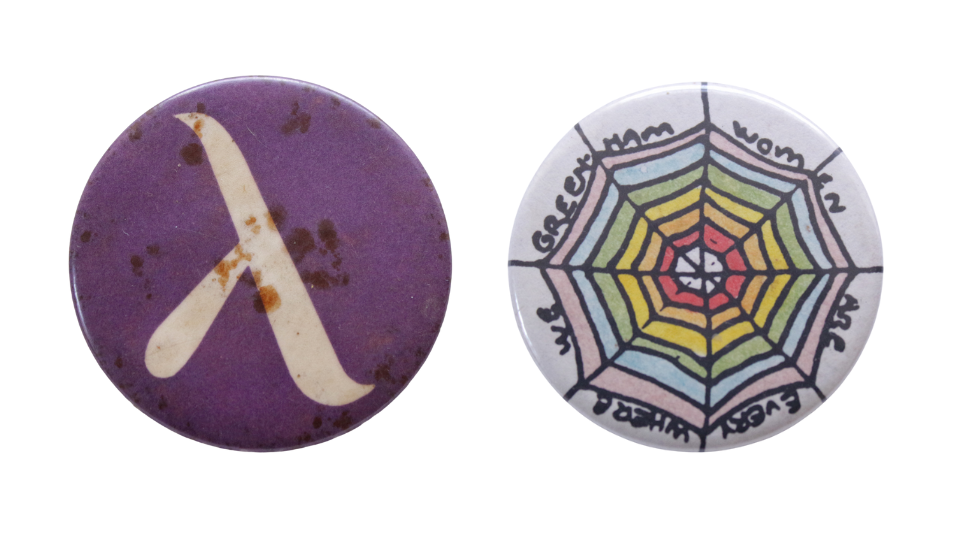 Purple badge with the Greek letter lambda in white and Circular white badge with a hand-drawn illustration of a spiderweb and text around the edge, ‘WE GREENHAM WOMEN ARE EVERYWHERE’. The different layers of the spiderweb, like concentric circles, are the different colours of the rainbow Pride flag. From the centre out - red, orange, yellow, green, blue, purple.