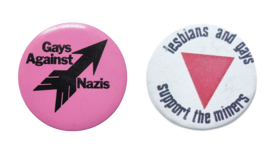 Pink circular badge with black text reading ‘Gays Against Nazis’ around a black arrow pointing to the top right, the logo of the Anti-Nazi League and a round white badge, with ‘Lesbians and Gays support the miners’ written in black around a pink triangle.