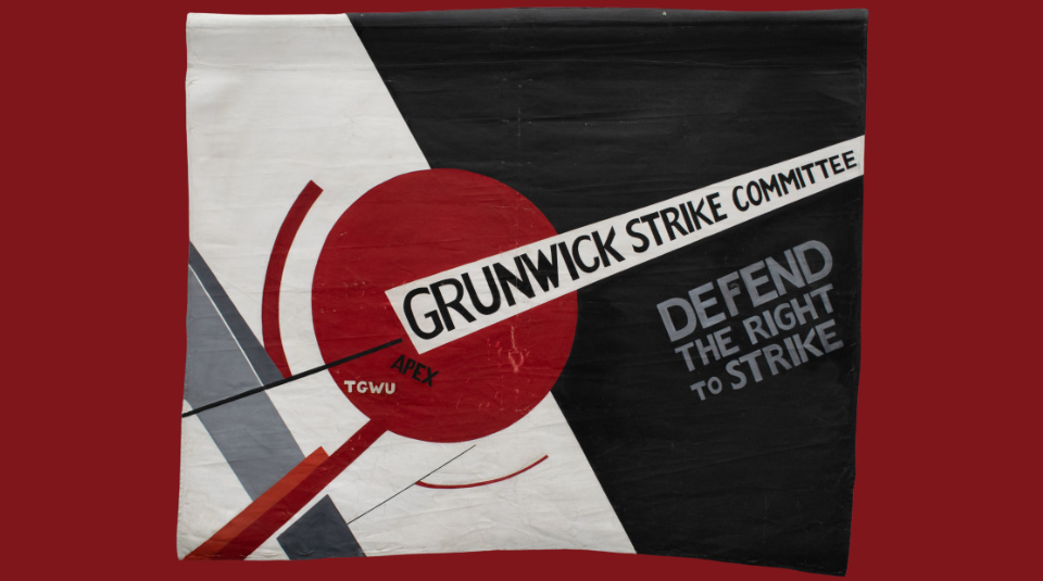 Image of A black and white banner with a geometric design which includes a large red circle, The text on the banner reads ‘GRUNWICK STRIKE COMMITTEE’ and ‘DEFEND THE RIGHT TO STRIKE,’ the acronyms 