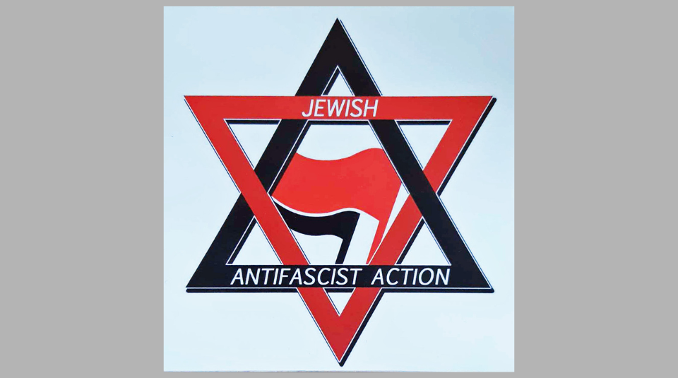 Image of Jewish Antifascist Action sticker, with a red and black Star of David and a red and a black flag in the centre. The words 'Jewish Antifascist Action' are written in the Star of David in white.