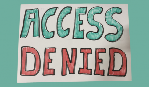Image of A handwritten white placard. Green and red writing says ‘Access Denied’.