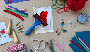 Image of Colourful materials laid out including ribbons, thread, wool, ink roller and string