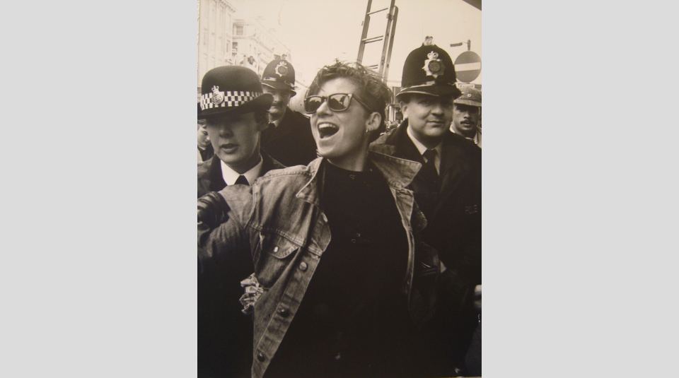 Image of Black & White photograph of a person being escorted by two Police officers