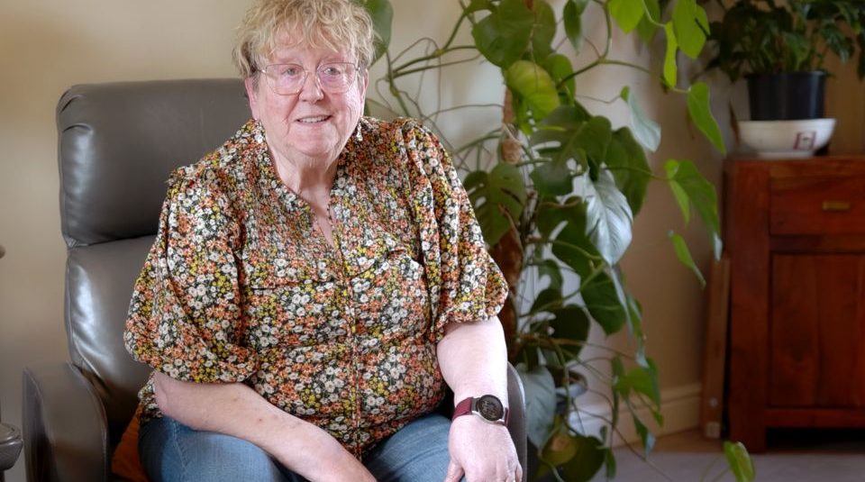 Image of Colour photograph of a person sat indoors on a leather chair.