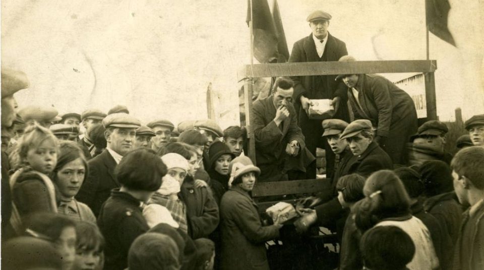 Image of Historic photograph of a crowd of people, giving and receiving parcels