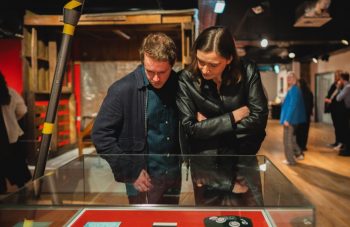 Image of Tow people looking into a glass case of objects