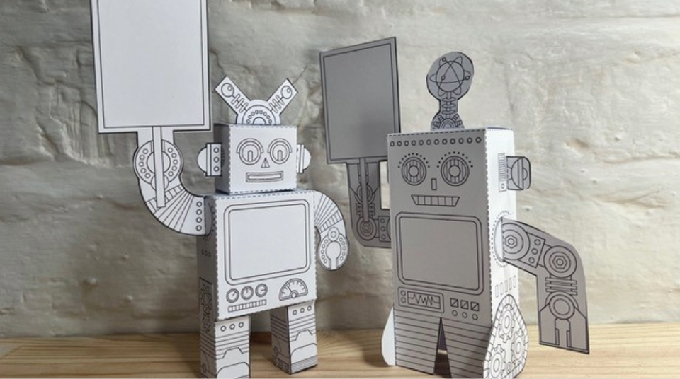 Image of Colour photograph of two mini robot models made from sheets of paper.