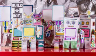 Image of Colour photograph of a crowd of mini robot models made from sheets of paper.