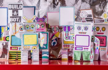 Image of Colour photograph of a crowd of mini robot models made from sheets of paper.