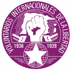 Purple circular logo with a white raised fist and white text including: 'Voluntarios Internacionales De La Libertad'.