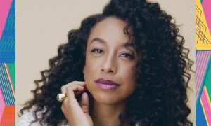 Colour photograph of a woman with long curly hair and bright lipstick.