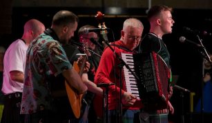 Image of Photograph of a five-member band performing with an accordion, guitar, and double bass.