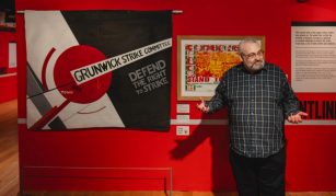 Image of A black and white banner with a geometric design including a large red circle, and text including: 'Grunwick Strike Committee, Defend The Right To Strike'.