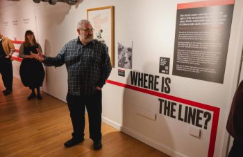 Image of Colour photograph of a person leading a tour in a gallery.