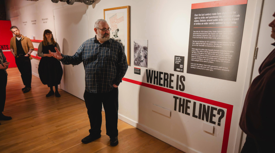 Image of Colour photograph of a person leading a tour in a gallery.