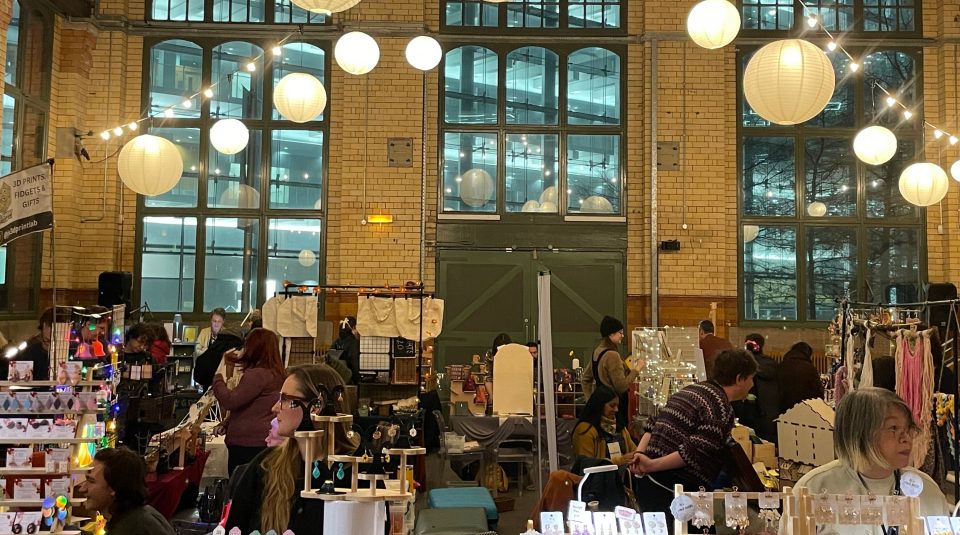 Image of Market stalls at PHM with shoppers and stall holders.