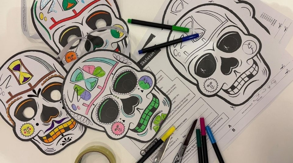 Image of Flat lay of skeleton mask with activity sheet, felt pens, scissors and tape