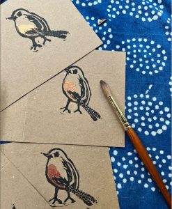 Colour photograph of cards featuring a lino print robin design.